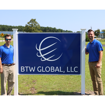 Brent and Trent Wynne next to BTW Global sign