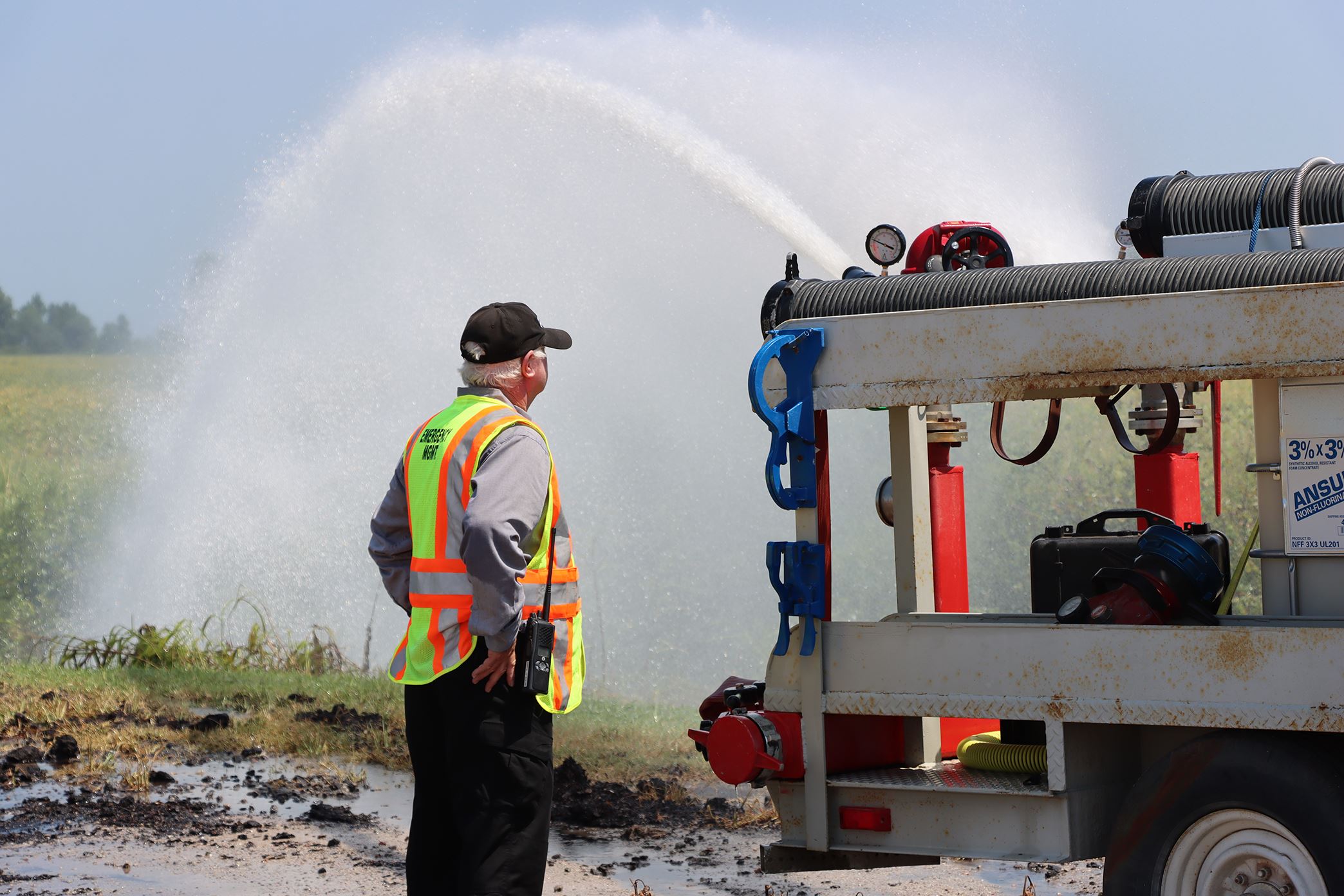 An official monitors a firefighting apparatus during the water shuttle operation